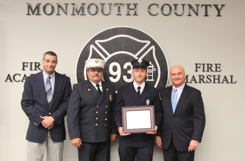 Fire Academy Director Armand Guzzi, Monmouth County Fire Marshal Henry Stryker III and Freeholder John P. Curley (right) congratulate the recipient of the Class 103 Ronald Fitzpatrick Firefighter 1 Award, John H. Harold (second from right) of the Englishtown Fire Company, at the Monmouth County Fire Academy graduation on June 25, 2014 in Howell, NJ.